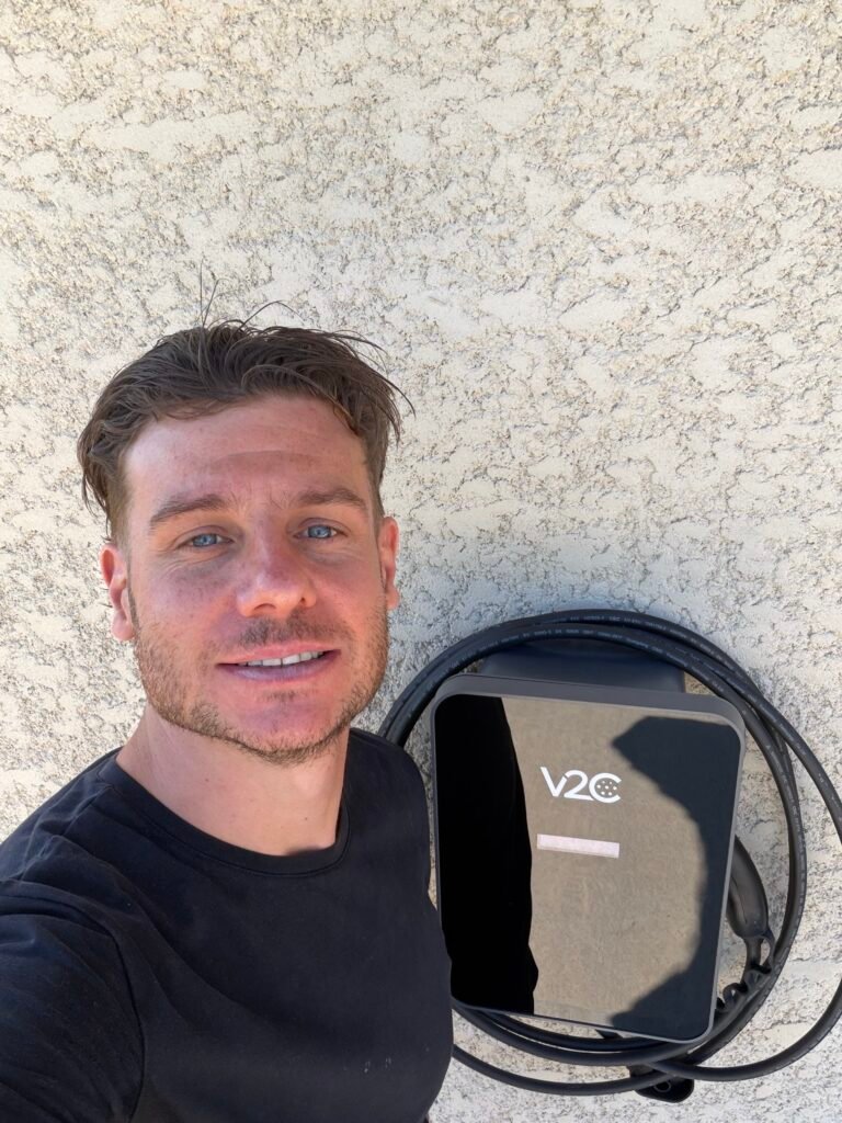 Fabien, installateur de bornes de recharge, à côté d'une borne V2C installée
